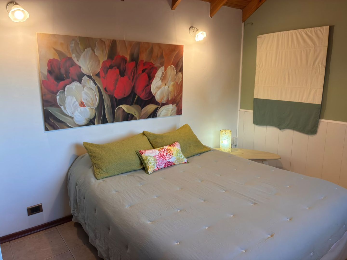 Dormitorio con cama matrimonial y mesa de luz